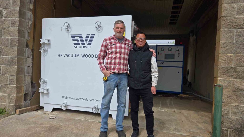 Carlos (engineer) and JD (customer) smiling after completing the HF vacuum wood dryer setup at JD’s factory.